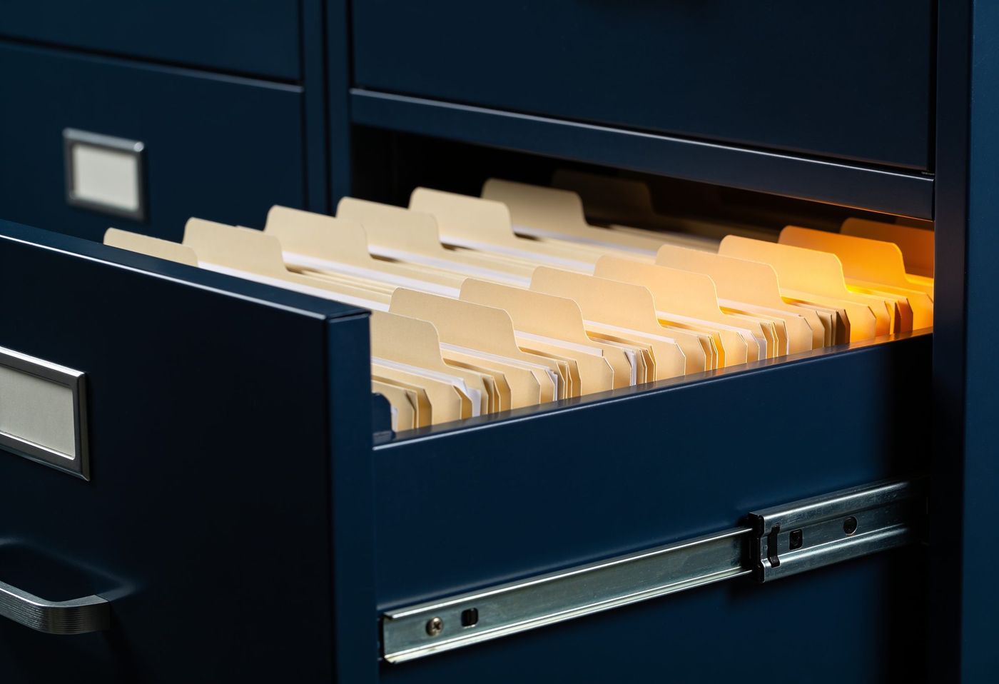 A navy filing drawer pulled open with neatly aligned folders